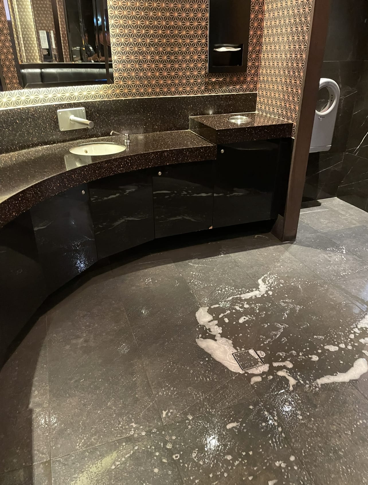 Freshly mopped polished stone floor in an upscale restroom