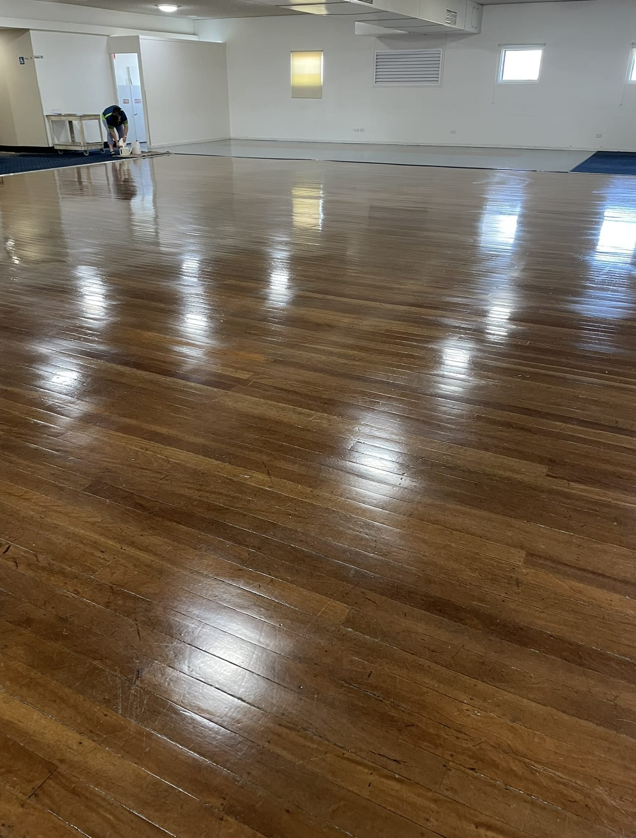 Polished timber floor restored by Cheetah Maintenance in a large function hall